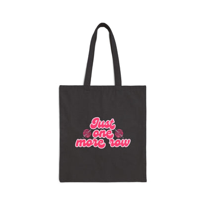 Black tote bag with pink text 'Just one more row' on a white background