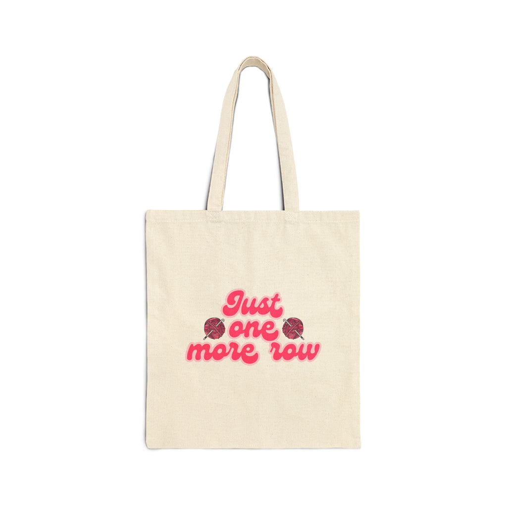 Beige tote bag with pink text 'Just one more row' on a white background