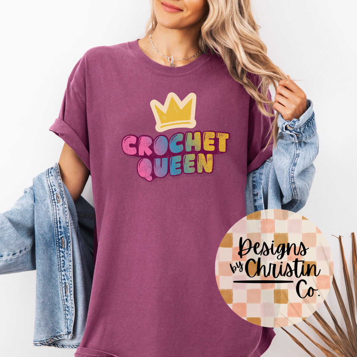 Person wearing a purple t-shirt with 'Crochet Queen' text and a crown graphic, standing against a white background.