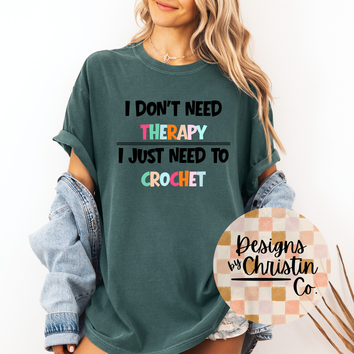 Person wearing a green t-shirt with colorful text 'I don't need therapy, I just need to crochet' and a visible brand logo.