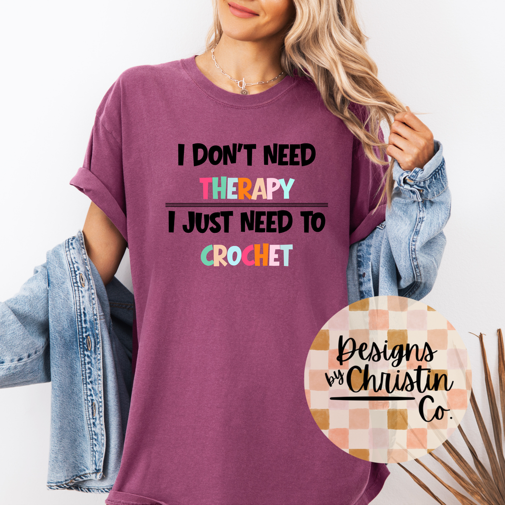 Person wearing a purple t-shirt with colorful text and 'Designs by Christin Co.' logo.