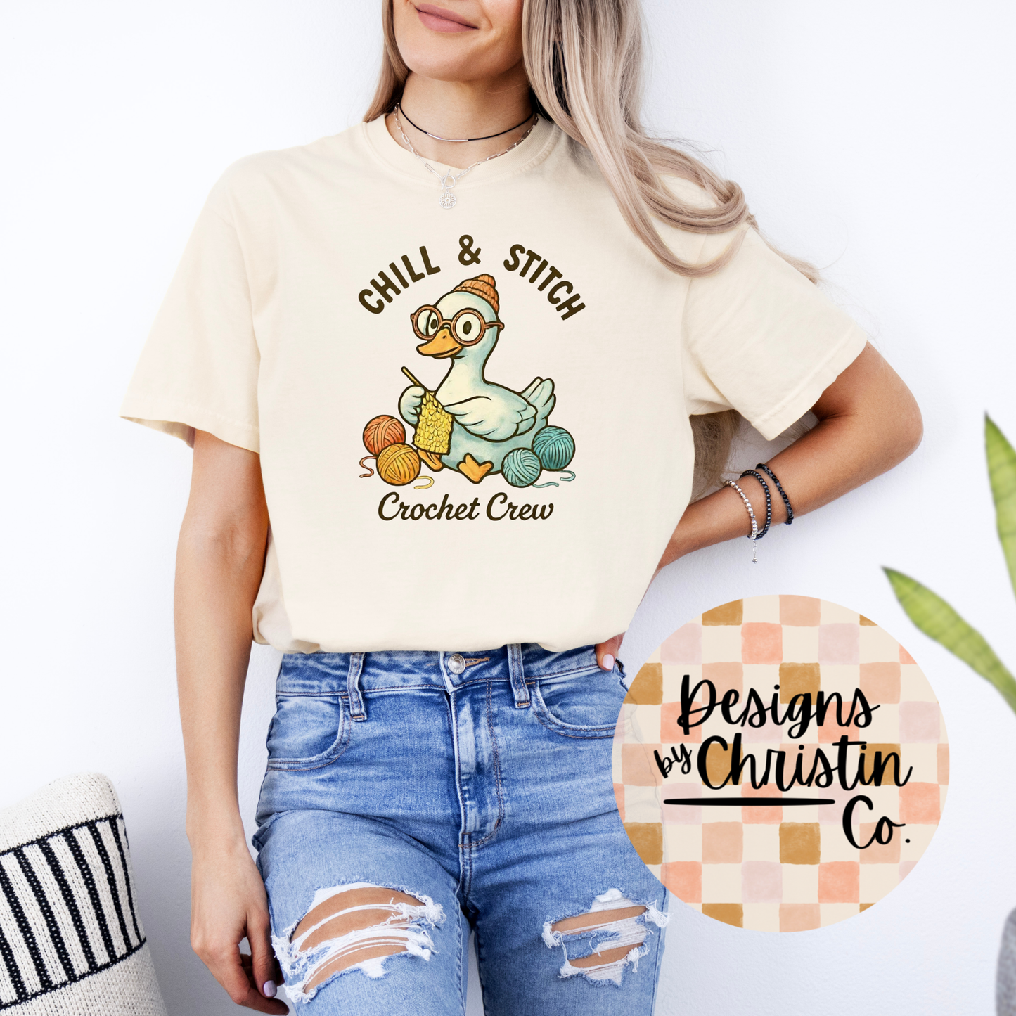 Person wearing a cream t-shirt with 'Chill & Stitch Crochet Crew' design, standing against a white background.