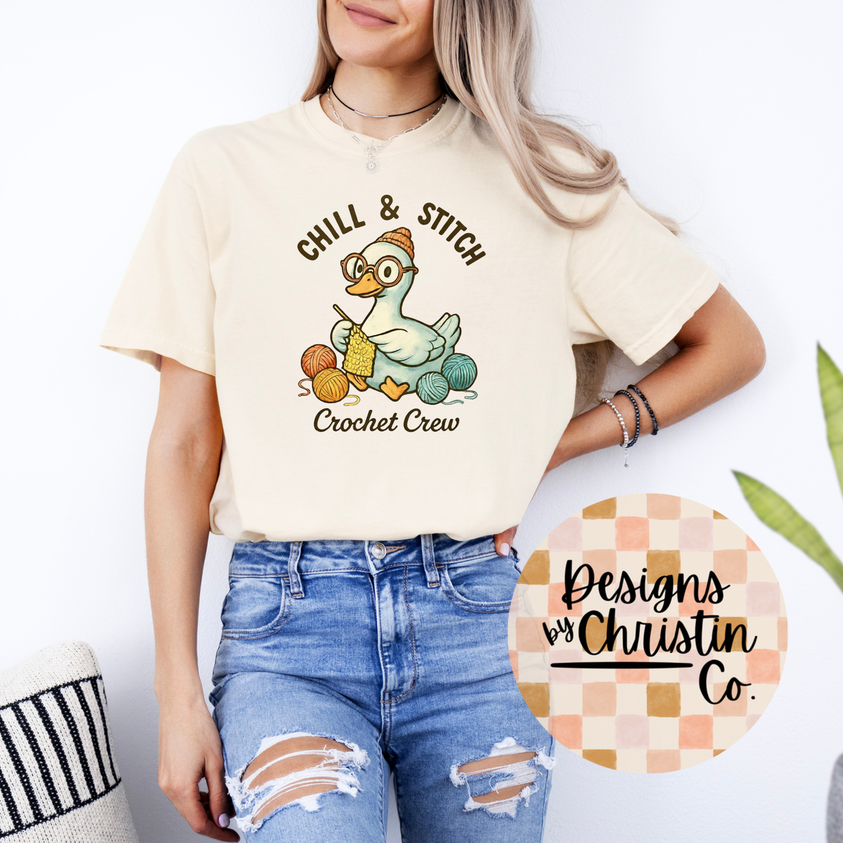 Person wearing a cream t-shirt with 'Chill & Stitch Crochet Crew' design, standing against a white background.
