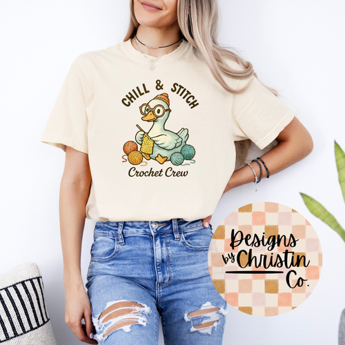 Person wearing a cream t-shirt with 'Chill & Stitch Crochet Crew' design, standing against a white background.