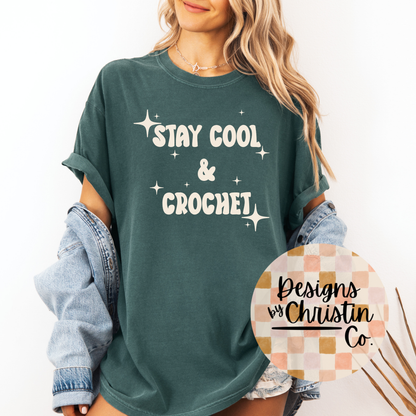 Person wearing a green t-shirt with 'Stay Cool & Crochet' text, standing against a white background.