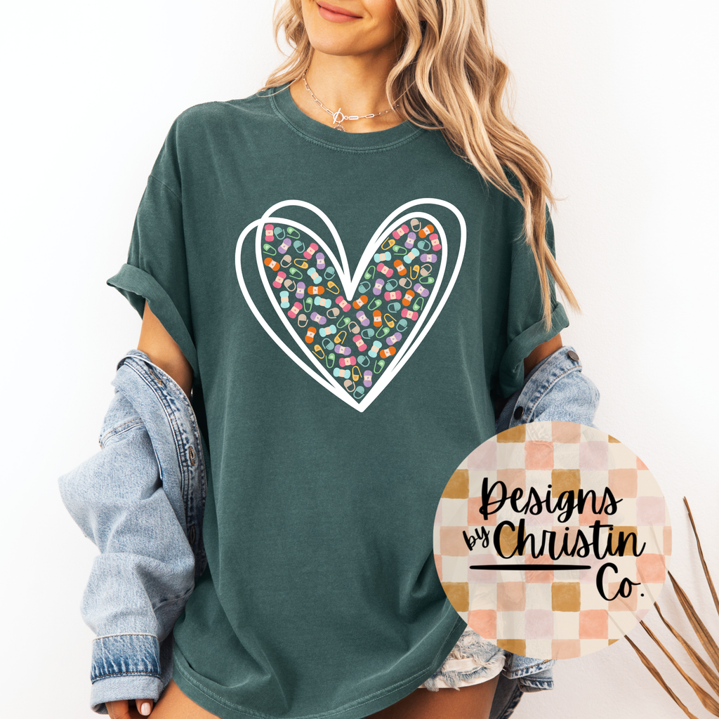 Person wearing a green t-shirt with a colorful heart design, standing against a white background.