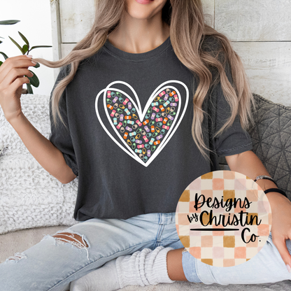 Person wearing a dark gray t-shirt with a colorful heart design, sitting on a couch.