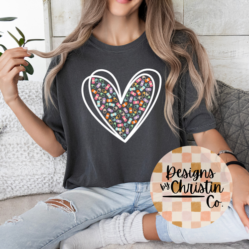 Person wearing a dark gray t-shirt with a colorful heart design, sitting on a couch.