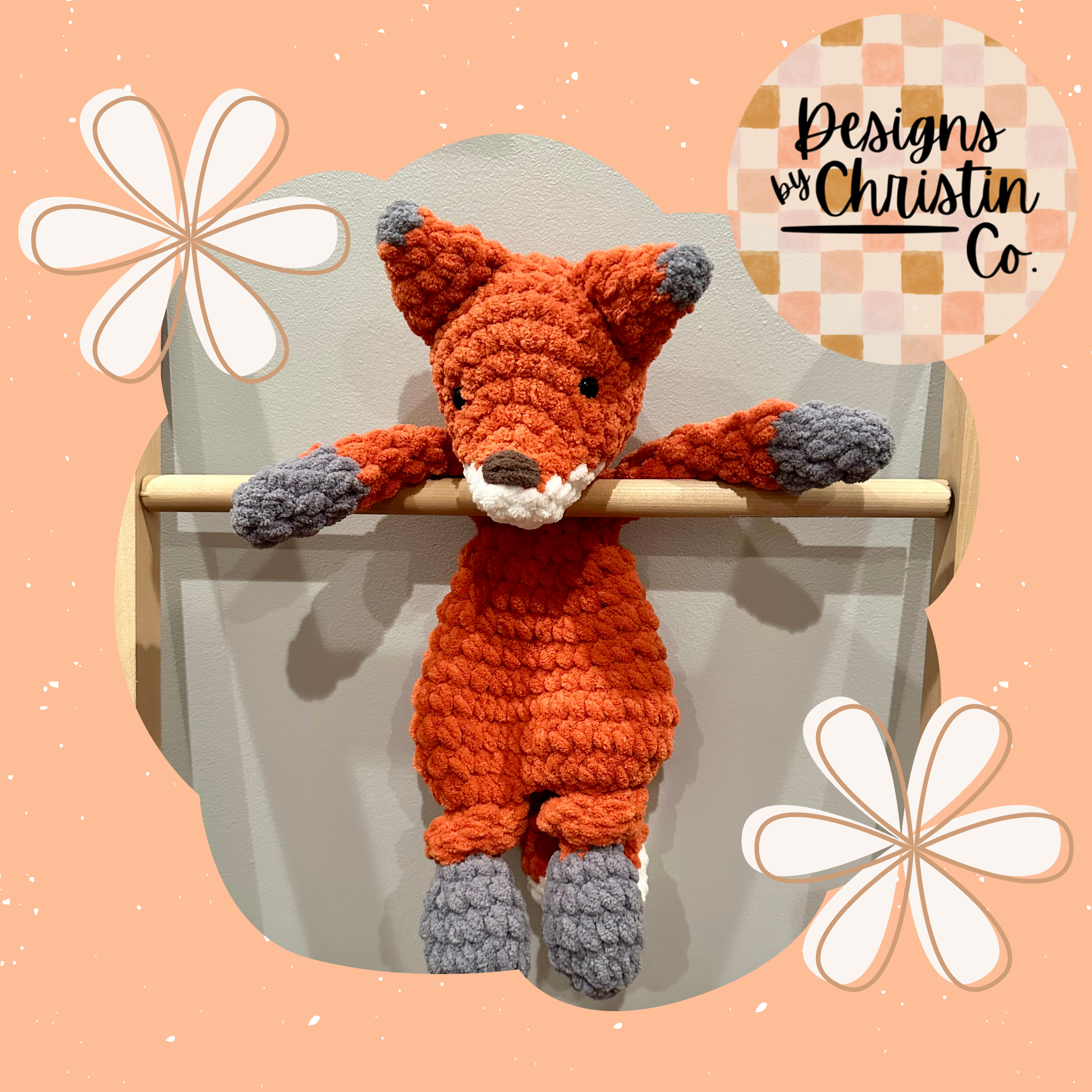A crochet orange and gray fox lovey baby plush toy with a stuffed head and an unstuffed body.